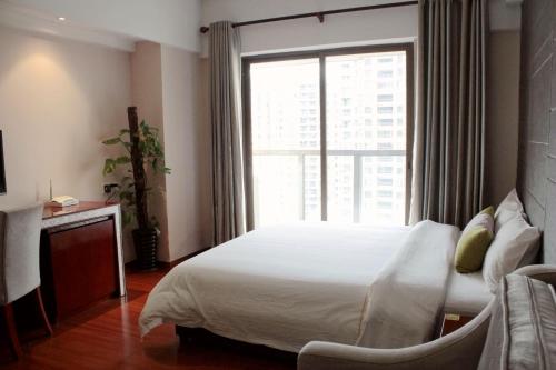 a bedroom with a bed and a large window at Guangzhou Victory Apartment in Guangzhou