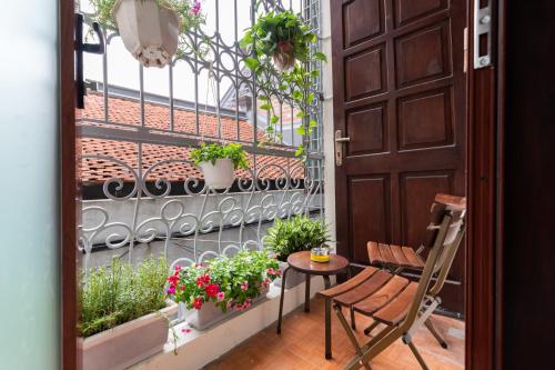 a balcony with a table and chairs and plants at Nusmile's Hostel and Travel in Hanoi