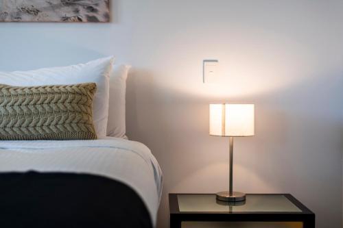 a bedroom with a bed and a lamp on a table at Pacific Marina Apartments in Coffs Harbour