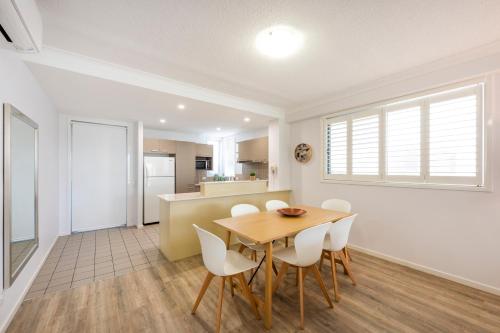 a kitchen and dining room with a table and chairs at Pacific Marina Apartments in Coffs Harbour
