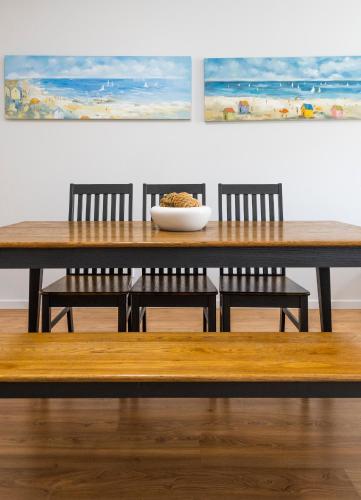 a wooden table with chairs and a bowl of food on it at Pacific Marina Apartments in Coffs Harbour