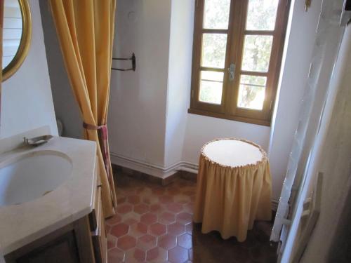 La salle de bains est pourvue d'un lavabo et d'un tabouret à côté d'une fenêtre. dans l'établissement La Frandomière, à Saint-Martin-de-Londres