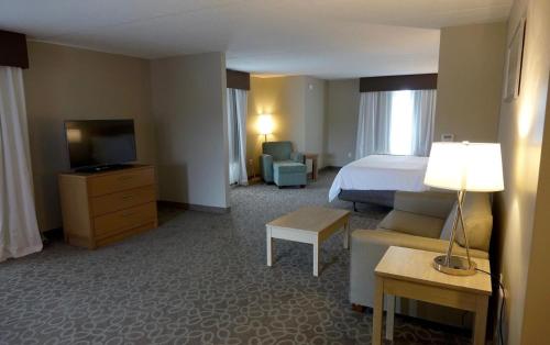 a hotel room with a bed and a television at Holiday Inn Express & Suites Oshawa Downtown - Toronto Area by IHG in Oshawa