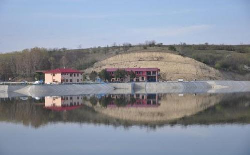 a reflection of a house in a body of water at Complex Domneasca in Seimeni