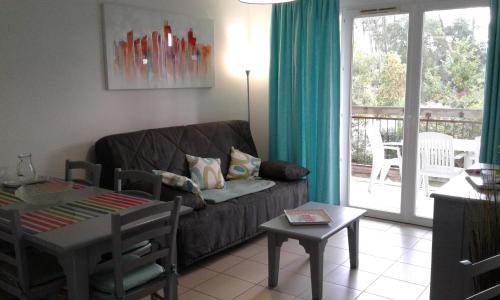 un salon avec un canapé et une table dans l'établissement T3 Lagon Ondres plages avec piscine et tennis, à Ondres