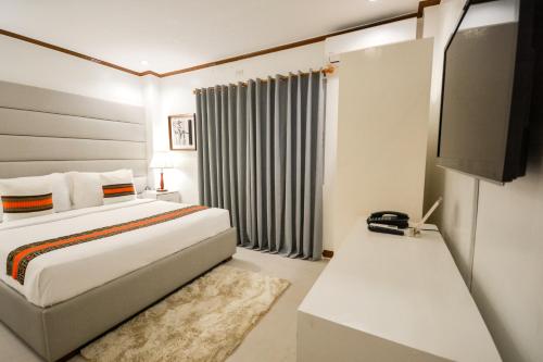 a hotel room with a bed and a window at Sur Beach Resort Boracay in Boracay