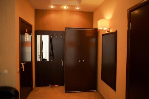 een badkamer met een zwarte koelkast en een spiegel bij Bogemia City Hotel in Saratov
