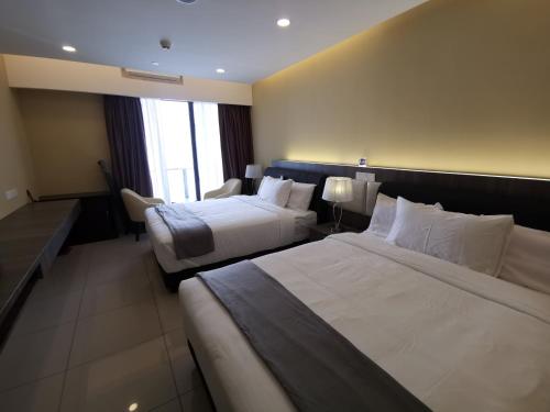 a hotel room with two beds and a window at Avanie Suite at Genting Highland in Genting Highlands