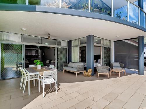 a house with a patio with a table and chairs at Stunning Ground Floor City Apartment 104 in Cairns