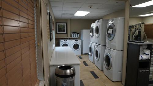 a laundry room with three washing machines and a washer and dryer at Candlewood Suites-West Springfield by IHG in West Springfield
