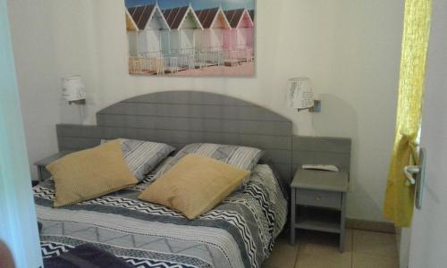 a bed with two pillows on it in a bedroom at T3 Soleil Ondres plages avec piscine et Tennis in Ondres