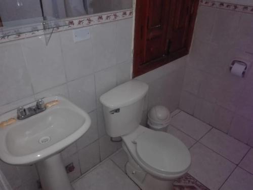 y baño con aseo blanco y lavamanos. en El MONARCA AREQUIPA, en Arequipa