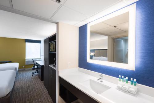 baño con lavabo y espejo grande en Holiday Inn Express Ramsey Mahwah, an IHG Hotel en Ramsey