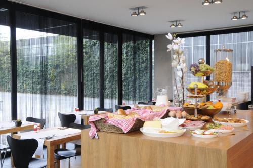 a dining room with a table with food on it at Hotel Corbie Lommel in Lommel
