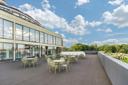 un patio avec des tables et des chaises à côté d'un bâtiment dans l'établissement Holiday Inn & Suites Pittsfield-Berkshires, an IHG Hotel, à Pittsfield