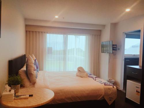 a bedroom with a large bed with a window at ODYSSEY APOLLO BAY in Apollo Bay