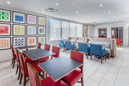 a dining room with tables and chairs and paintings on the wall at Holiday Inn Express Ramsey Mahwah by IHG in Ramsey