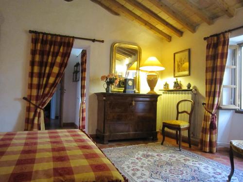 une chambre avec un lit, un miroir et une chaise dans l'établissement La Frandomière, à Saint-Martin-de-Londres