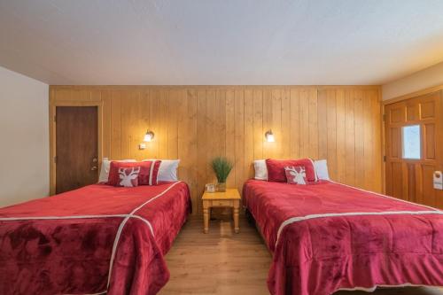 two beds in a room with red sheets at Black Forest Lodge in Big Bear Lake
