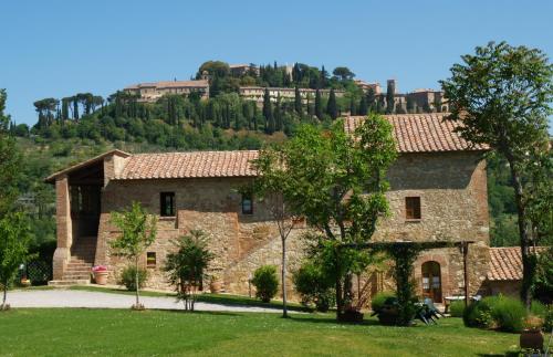 モンテプルチャーノにあるAgriturismo Nobileの背景に丘を背景に建つ大きな石造りの家