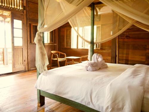 a bedroom with a canopy bed with a stuffed animal on it at Green Vanilla Bungalow in Sidemen