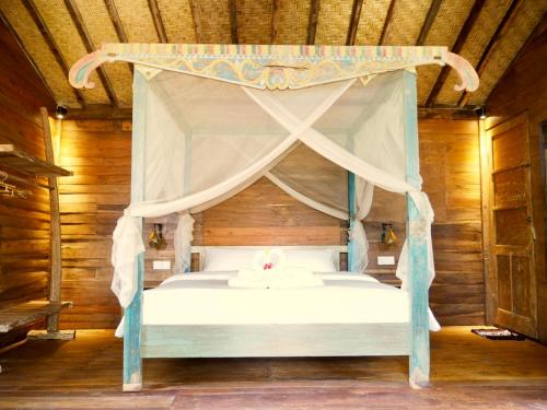 a bedroom with a bed with a canopy at Green Vanilla Bungalow in Sidemen