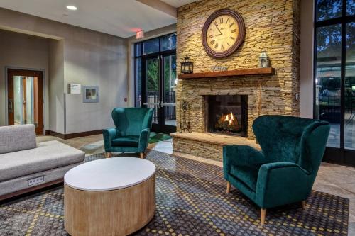 a living room with a couch and a fireplace at Holiday Inn Rocky Mount I-95 @ US 64 by IHG in Rocky Mount