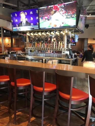 a bar with orange chairs and televisions above it at Holiday Inn Rock Springs by IHG in Rock Springs