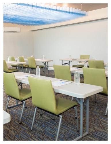 a row of tables and chairs in a room at Holiday Inn Express Pascagoula-Moss Point by IHG in Moss Point