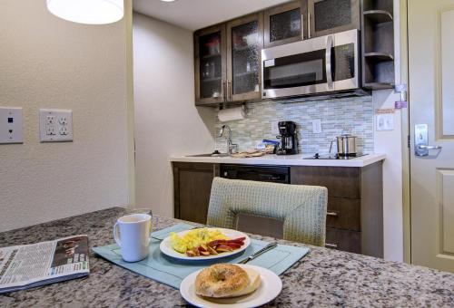 a kitchen with a table with two plates of food at Candlewood Suites Richmond - West Broad by IHG in Richmond
