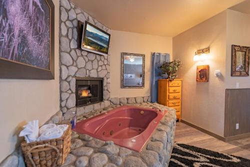 a bathroom with a red tub in a stone wall at Black Forest Lodge in Big Bear Lake