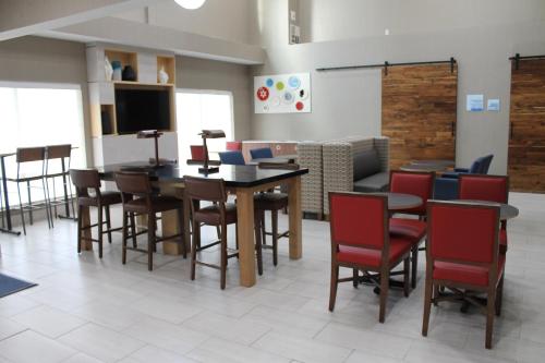 a dining room with tables and chairs and a tv at Holiday Inn Express & Suites - Tulare by IHG in Tulare