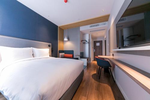 a hotel room with a large bed and a desk at Holiday Inn Express Shanghai Tangzhen by IHG - 20 mins to PVG Airport and Disney land in Shanghai