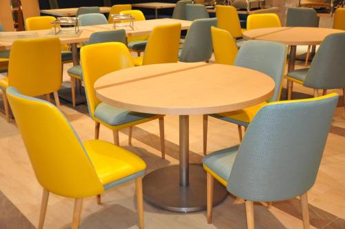 a row of tables and chairs with yellow and blue chairs at Holiday Inn Express Shanghai Zhenping by IHG in Shanghai