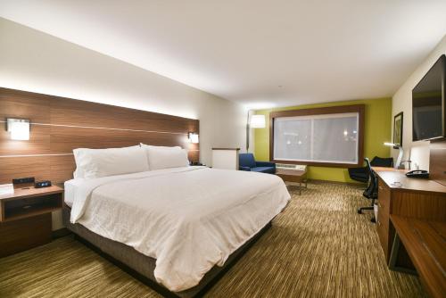 a hotel room with a bed and a flat screen tv at Holiday Inn Express & Suites Lehi - Thanksgiving Point by IHG in Lehi