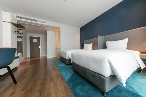 a bedroom with a large bed and a blue wall at Holiday Inn Express Shanghai Tangzhen by IHG - 20 mins to PVG Airport and Disney land in Shanghai