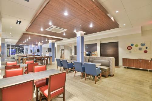 a restaurant with tables and chairs and a bar at Holiday Inn Express & Suites Lehi - Thanksgiving Point by IHG in Lehi