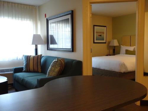a living room with a couch and a bed at Candlewood Suites Glen Allen-Short Pump in Glen Allen