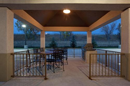 un patio con tavoli e sedie sul portico di Candlewood Suites Sheridan by IHG a Sheridan