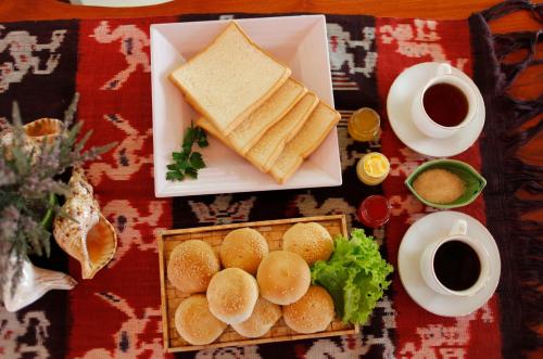 a plate of food with sandwiches and a cup of coffee at Pavilla Labuan Bajo in Labuan Bajo