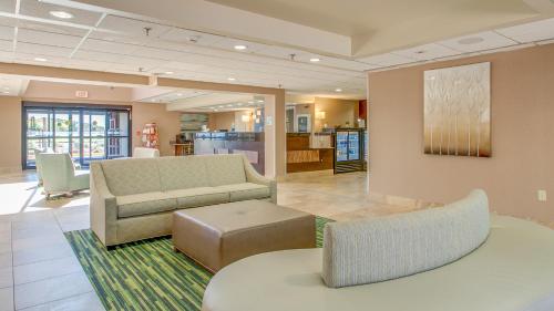 a lobby with a couch and a table and chairs at Holiday Inn Express Hotel & Suites Midlothian Turnpike by IHG in Richmond