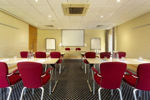 a conference room with tables and chairs and a projection screen at Holiday Inn Express Southampton - M27, J7 by IHG in Southampton