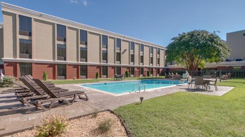 a pool in front of a building with chairs and a table at Holiday Inn Express Hotel & Suites Midlothian Turnpike by IHG in Richmond