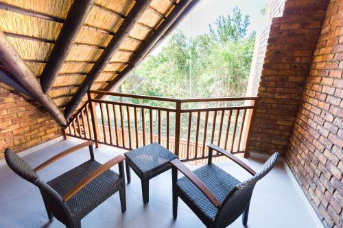 a porch with two chairs and a table on a balcony at Kruger Park Lodge Unit No. 610B in Hazyview