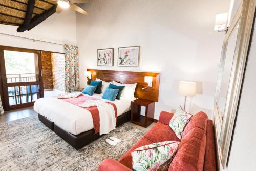 1 dormitorio con 1 cama y 1 sofá en Kruger Park Lodge Unit No. 610B, en Hazyview