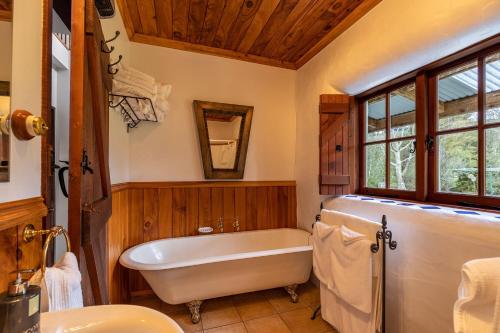 a bathroom with a tub and a sink at The Last Straw Cottage Nelson in Brightwater