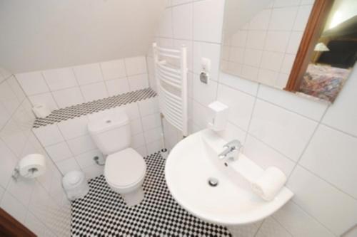 a white bathroom with a toilet and a sink at Galeria Pępowo in Żukowo