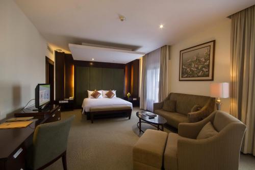 Habitación de hotel con cama y sofá en Hotel Santika Cirebon, en Cirebon