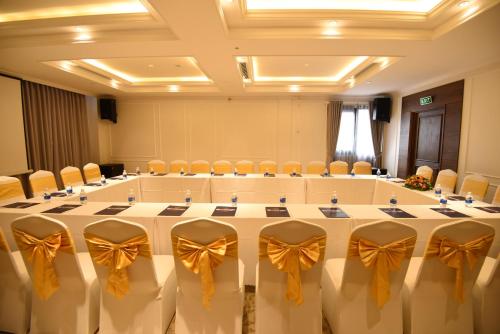 a large meeting room with a large table with bows at Phu Cuong Hotel Ca Mau in Cà Mau