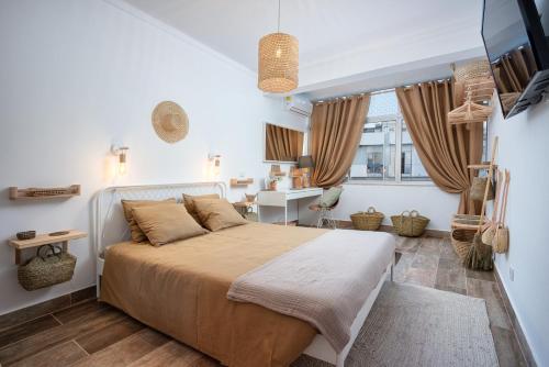 a bedroom with a large bed and a desk at Baixa de Faro Rooftop in Faro